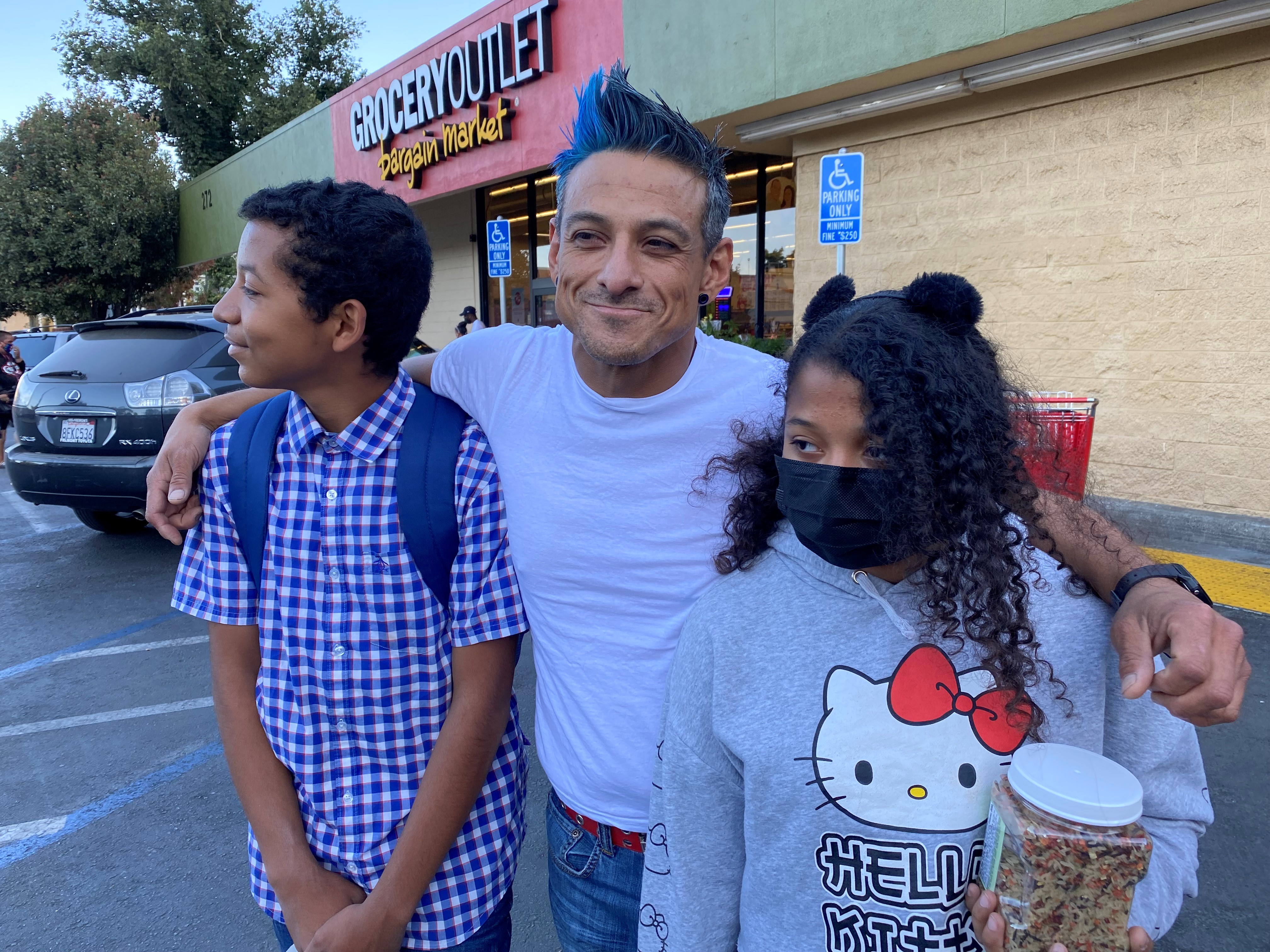 Francisco Pacheco with his two children outside of a grocery store