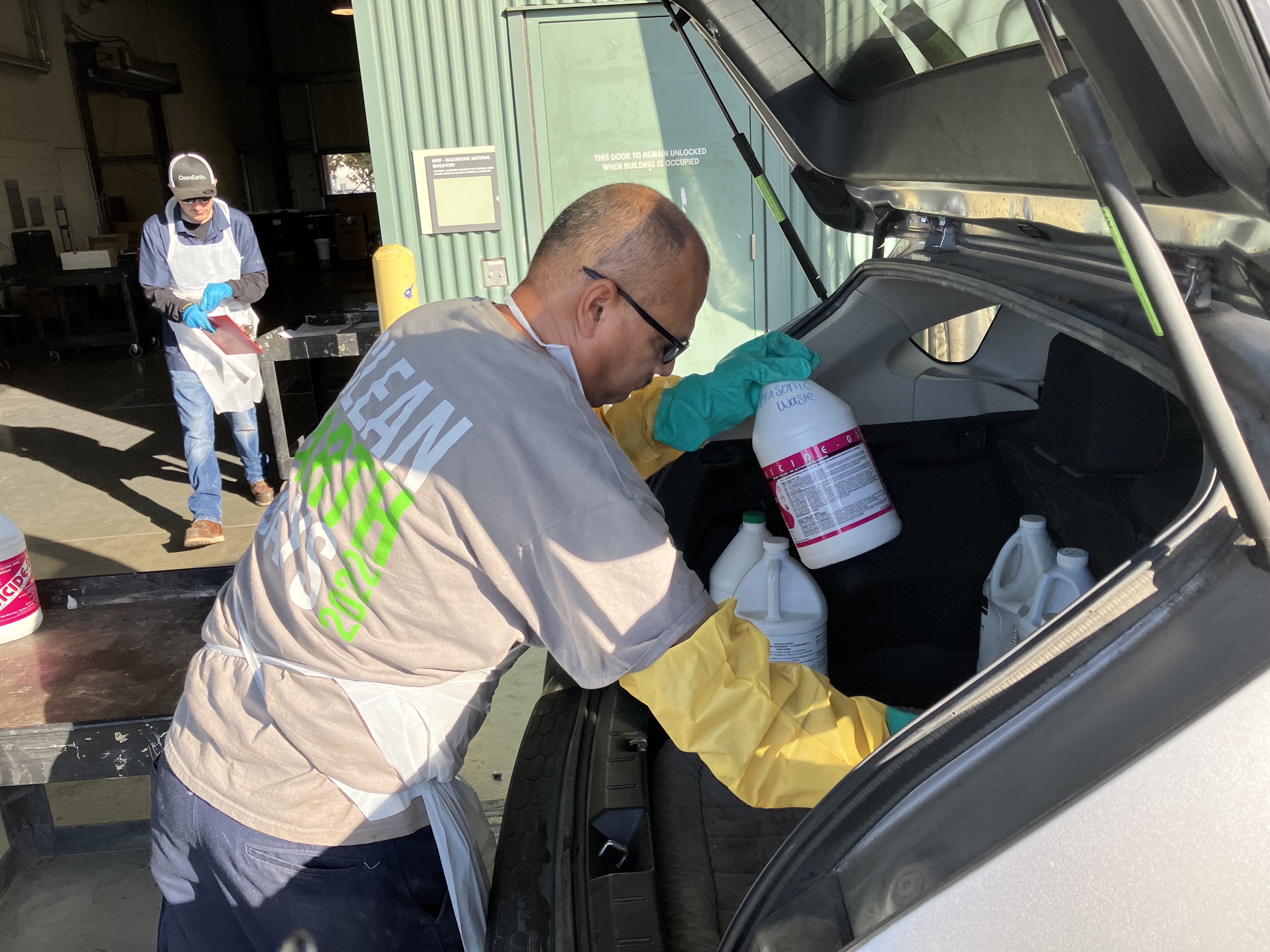 A technician removes hazardous waste from a vehicle.