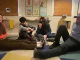 Four kids sitting on the floor talking