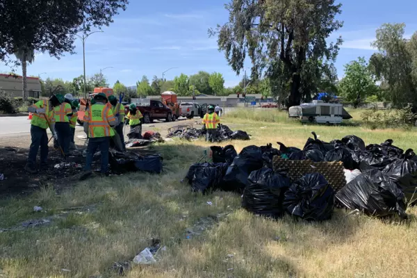 A cleanup crew and a bunch of garbage bags full of trash picked up from a field near the Monterey Highway in South San Jose. 