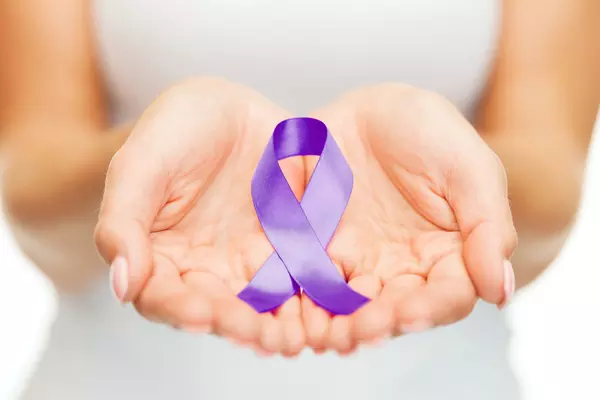 hands holding a purple ribbon