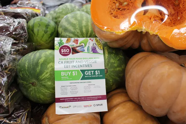 A flyer promoting the California Fruit and Vegetable EBT Pilot Project rests atop produce at a grocery store in San Jose.