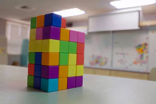A stack of colorful blocks sits on a desk.