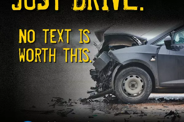 Graphic from campaign has a dark image of an automobile’s crushed front end in profile, with wreckage on the ground. Text states: JUST DRIVE. NO TEXT IS WORTH THIS. Visit JustDriveSCC.org to learn how you can help.