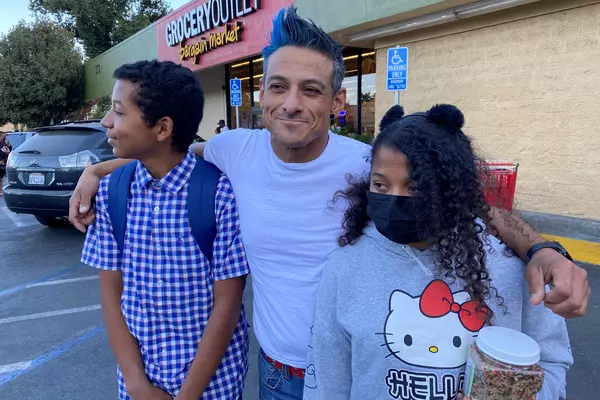 Francisco Pacheco with his two children outside of a grocery store