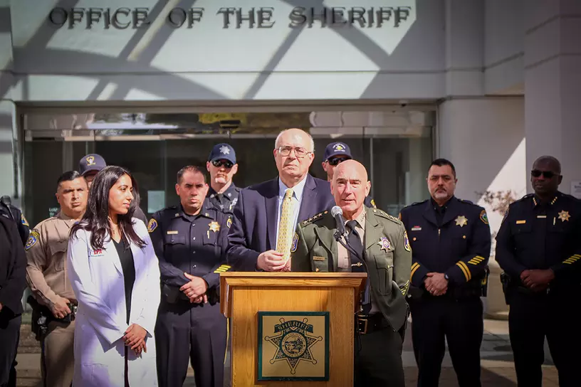 Supervisor Joe Simitian and others giving a speech in front of the Office of the Sheriff's building 