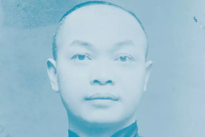 man looking straight into camera with gray background and blue filter