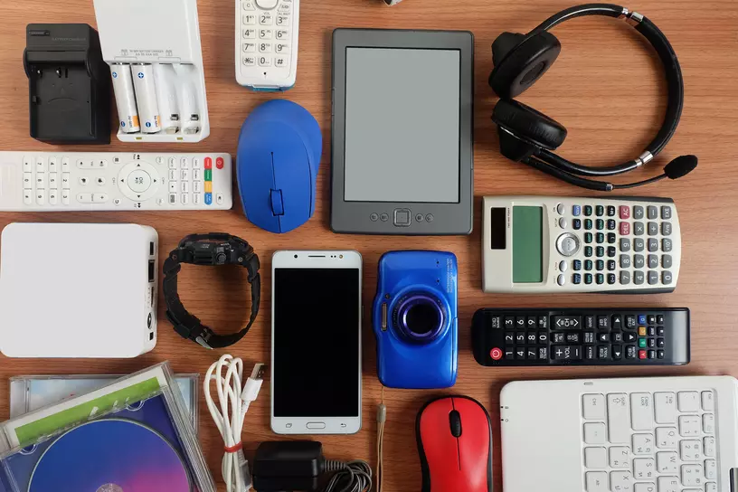 different types of technology items on a brown desk