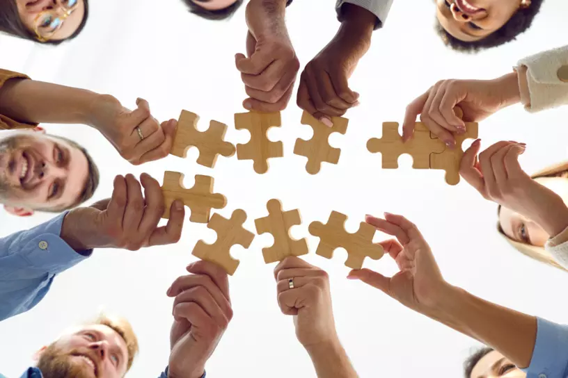 A group of people connecting puzzle pieces