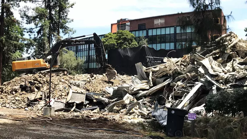 A bulldozer sorts through the steel, concrete, wood and other remains of a demolished building