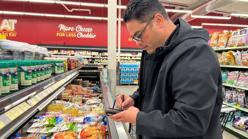 A Weights and Measure inspector scans the prices of products in a grocery to ensure the scan prices are accurate