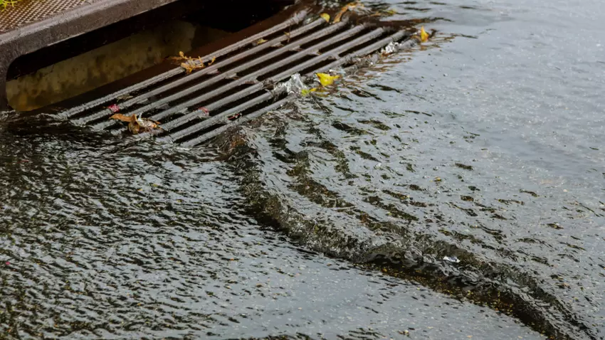 Water flowing into a storm drain inlet on a roadway