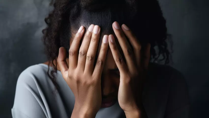 African American woman covering her face