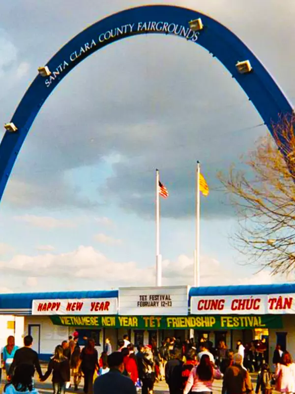 County fairground entrance's blue arc with people gathering for a New Year's celebration