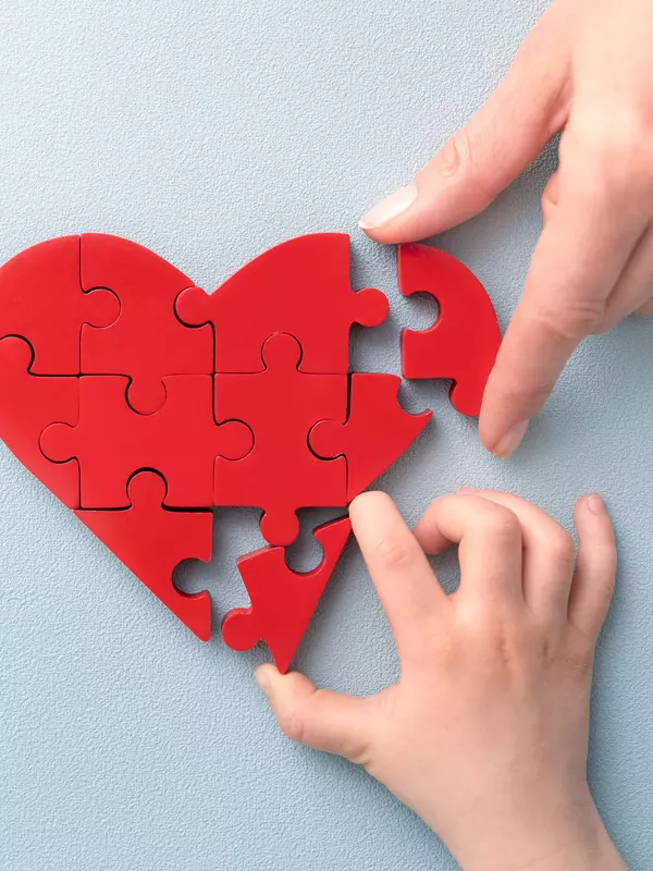 Hands with a puzzle shaped like a heart