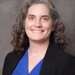 woman with curly gray hair wearing blue shirt and jacket