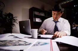 man working at desk with papers laid out