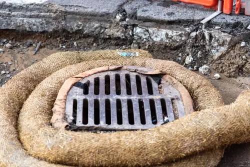 A fiber roll wrapped around a storm drain inlet for sediment control