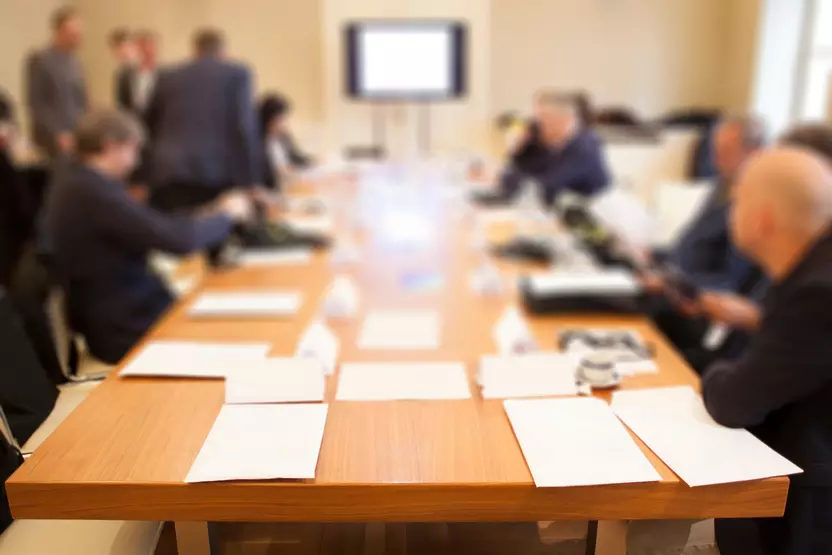 obscured image of staff around a conference table for negotiations
