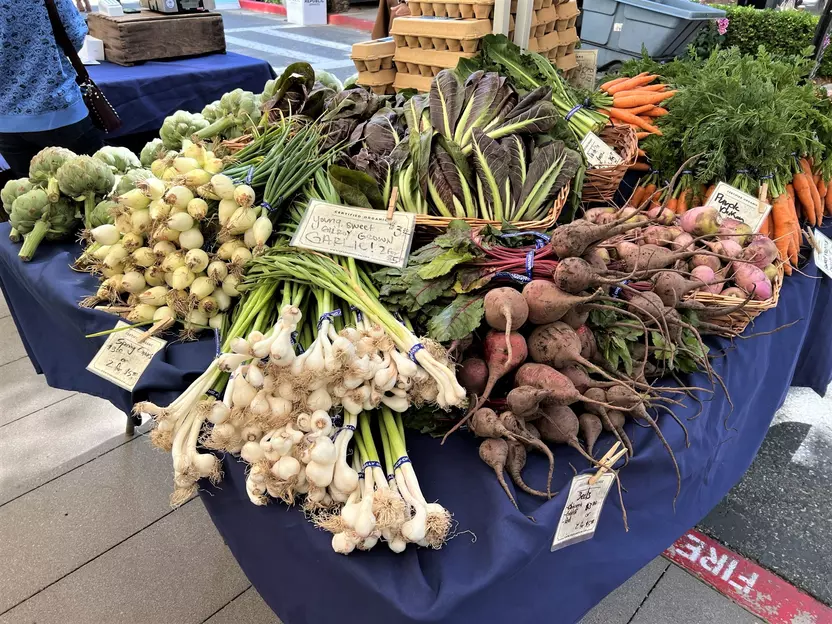A table is covered with organic vegetables at a farmers market.