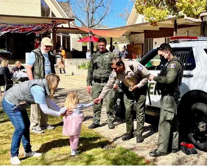 Sheriff's Office Deputies at a community event shaking a child's hand