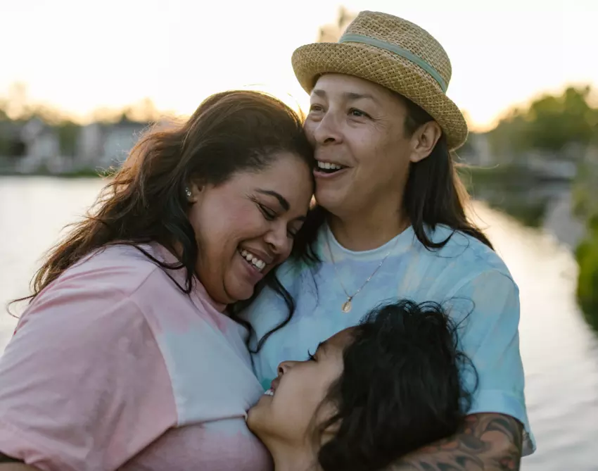 Lesbian couple with daughter hugging
